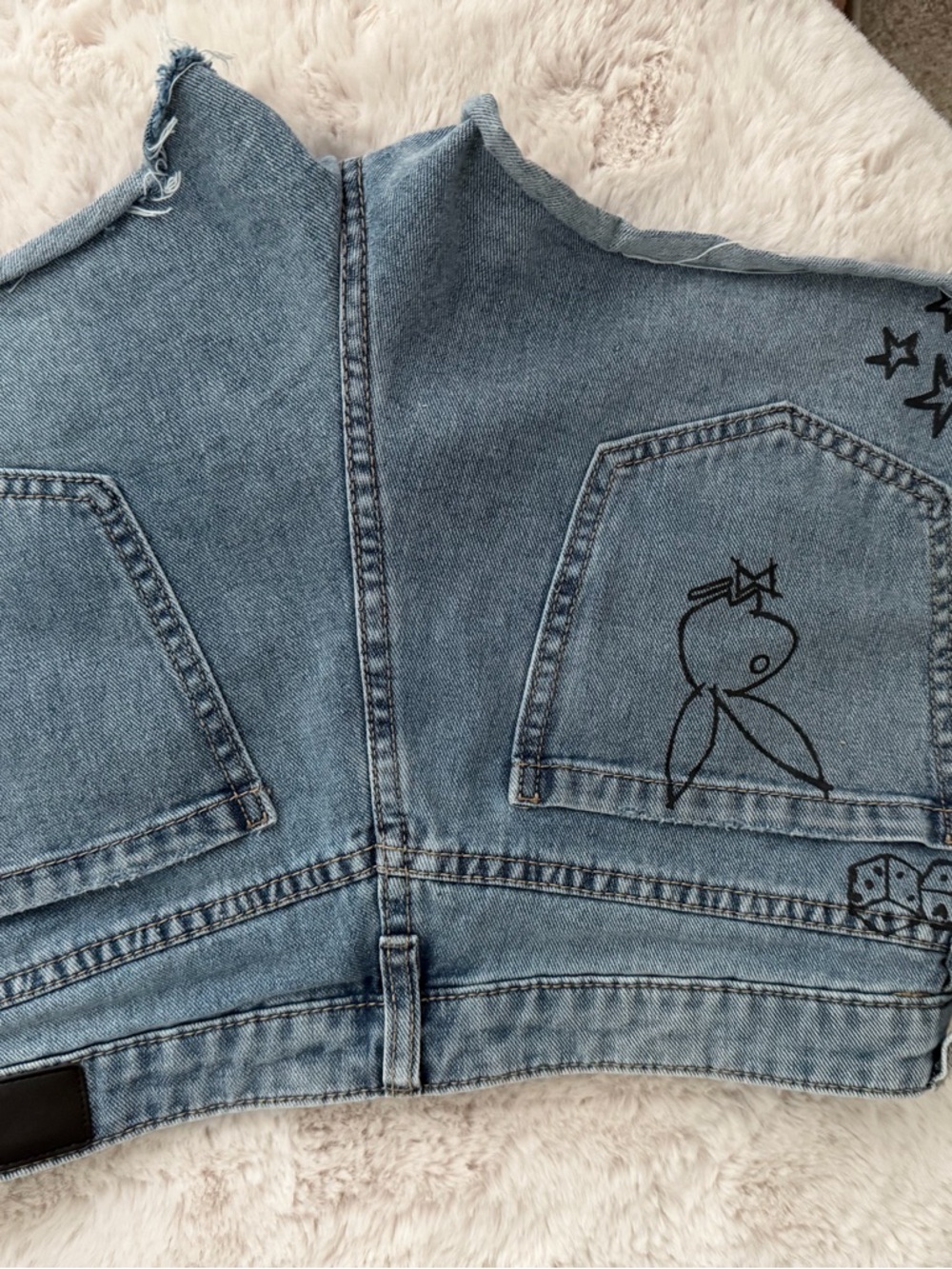 Women’s size 9 Denim playboy shorts with factory painted adornments.